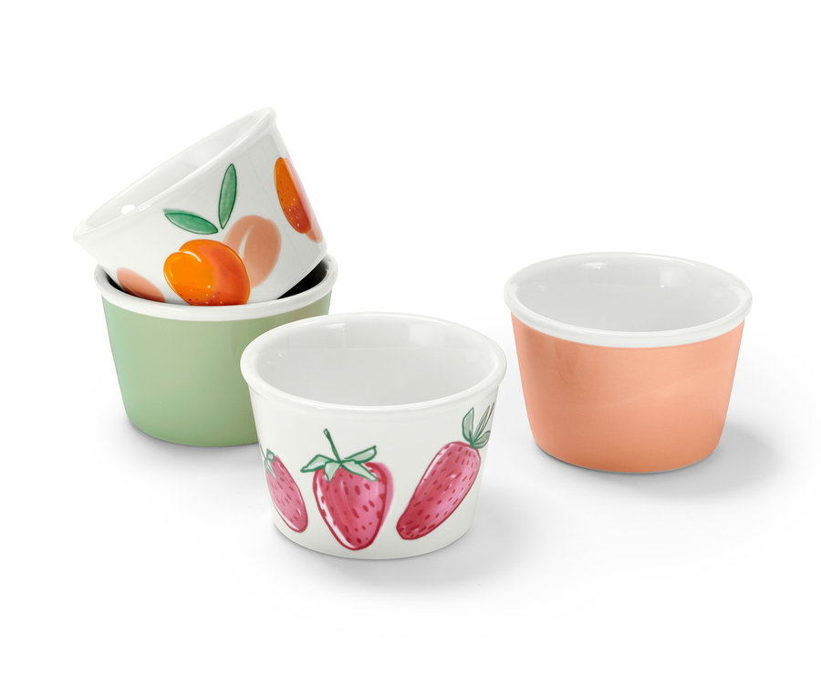 Quatre coupes à glace. Deux sont empilées l'une sur l'autre. L'une est vert clair, l'autre saumon et deux sont blanches avec des framboises et des abricots.