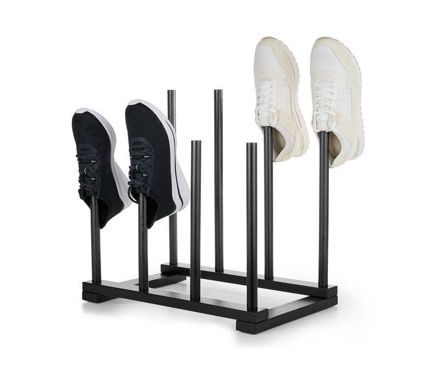 Deux paires de chaussures placées sur un porte-bottes noir.