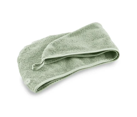 Une serviette turban verte sur un fond blanc.