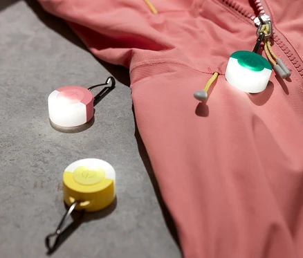 Une veste rose et trois pendentifs à LED.