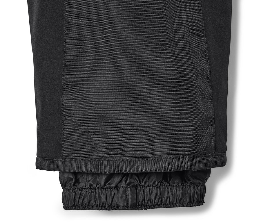 Gros plan sur le bas d'un pantalon de ski high-tech noir avec ourlet élastique.