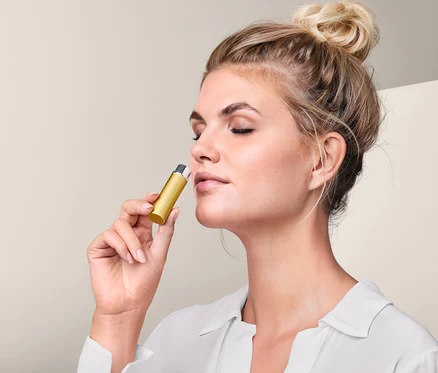 Femme utilisant un inhalateur de poche.