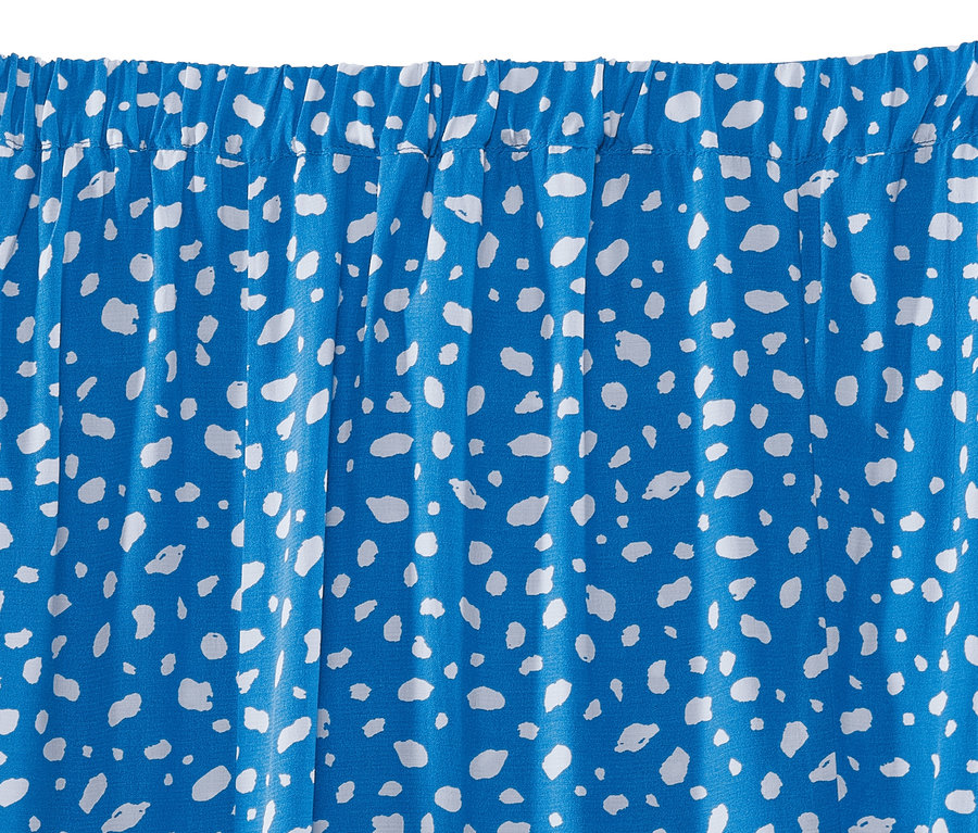 Gros plan d'une jupe bleue avec un imprimé blanc.