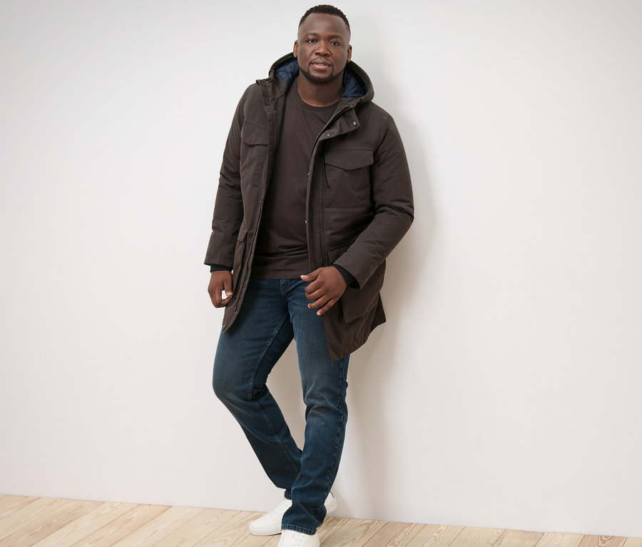 Un homme pose en parka et 2 t-shirts manches longues.