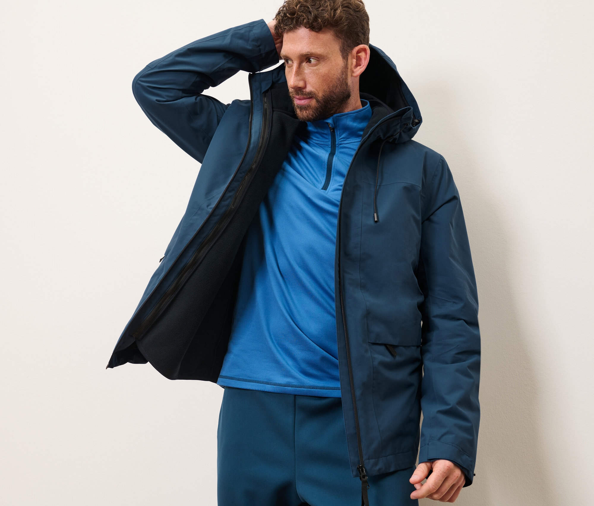 Un homme pose dans une veste d’extérieur avec gilet sans manches.