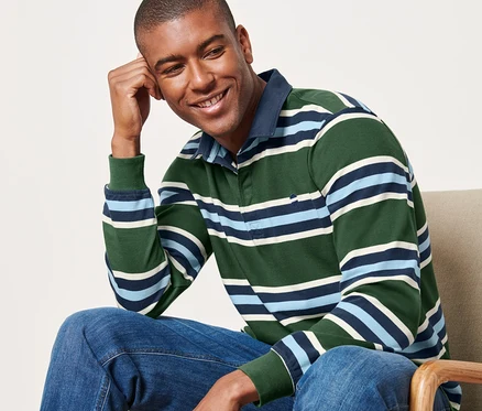 Un homme est assis sur une chaise et porte un polo manches longues.