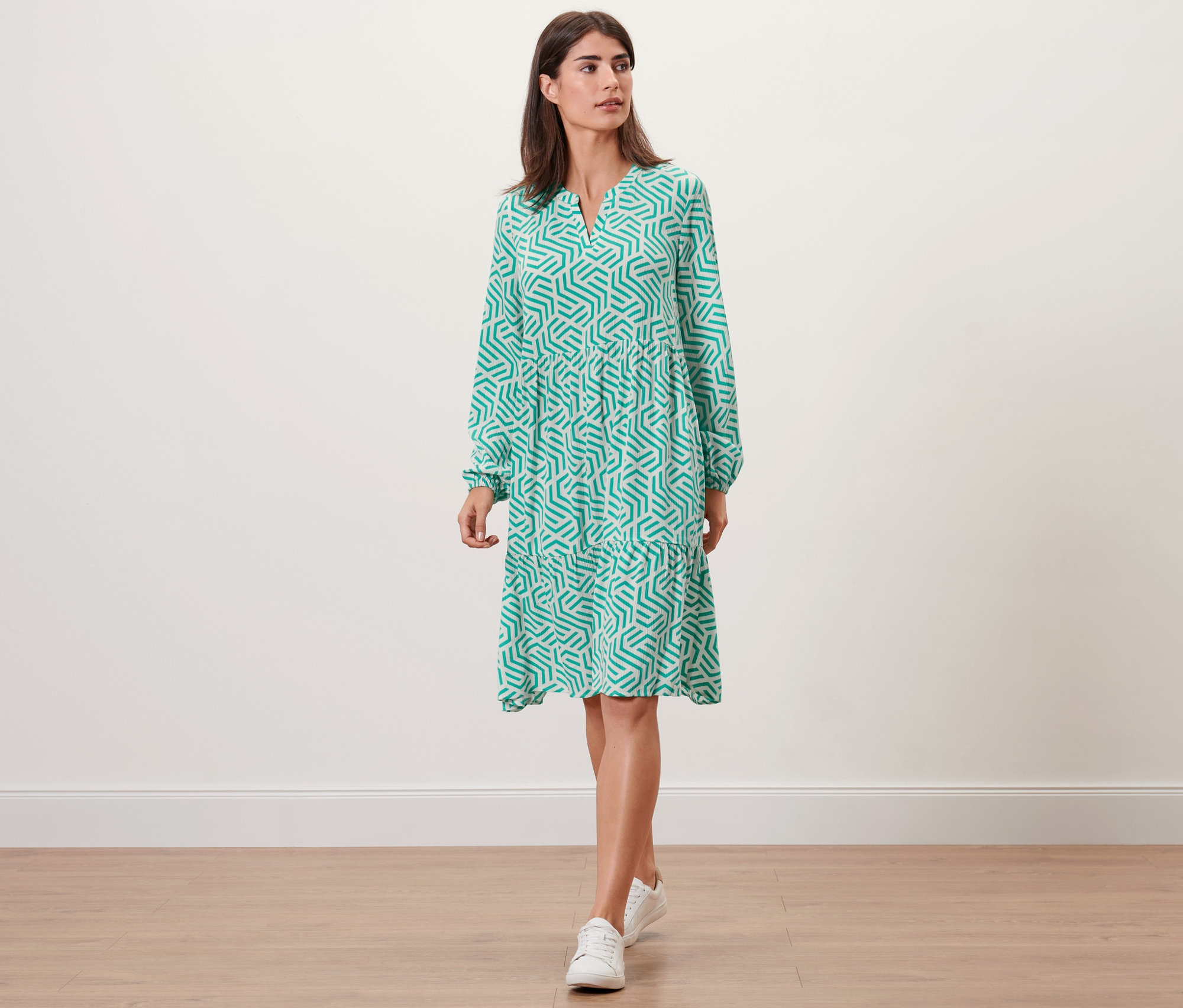 Une femme portant une robe tissée imprimée aqua marche.