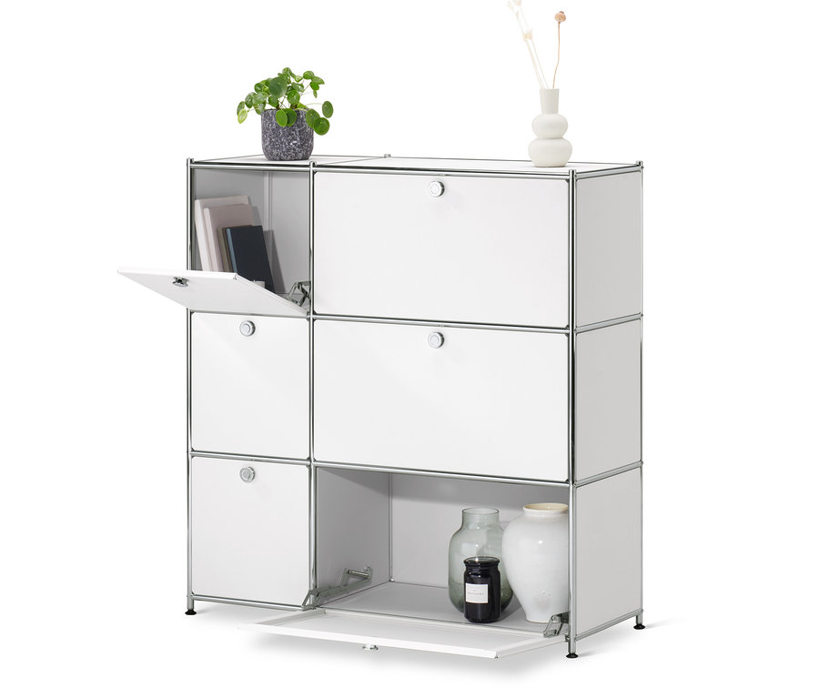 Une commode « CN3 » blanche avec 6 abattants dont un est ouvert. Un vase avec des fleurs et un pot de fleurs sont posés sur la commode.