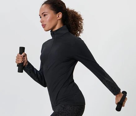 Femme en tenue de sport noire tenant 2 Haltères de course et de gymnastique dans chaque main.
