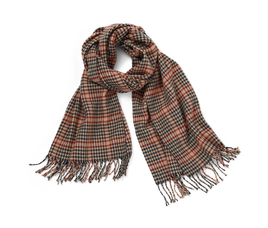 Une écharpe tissée à carreaux avec des franges repose sur un fond blanc.