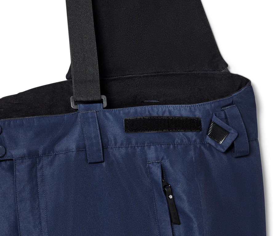 Détail d'un pantalon de ski bleu avec des bretelles noires.