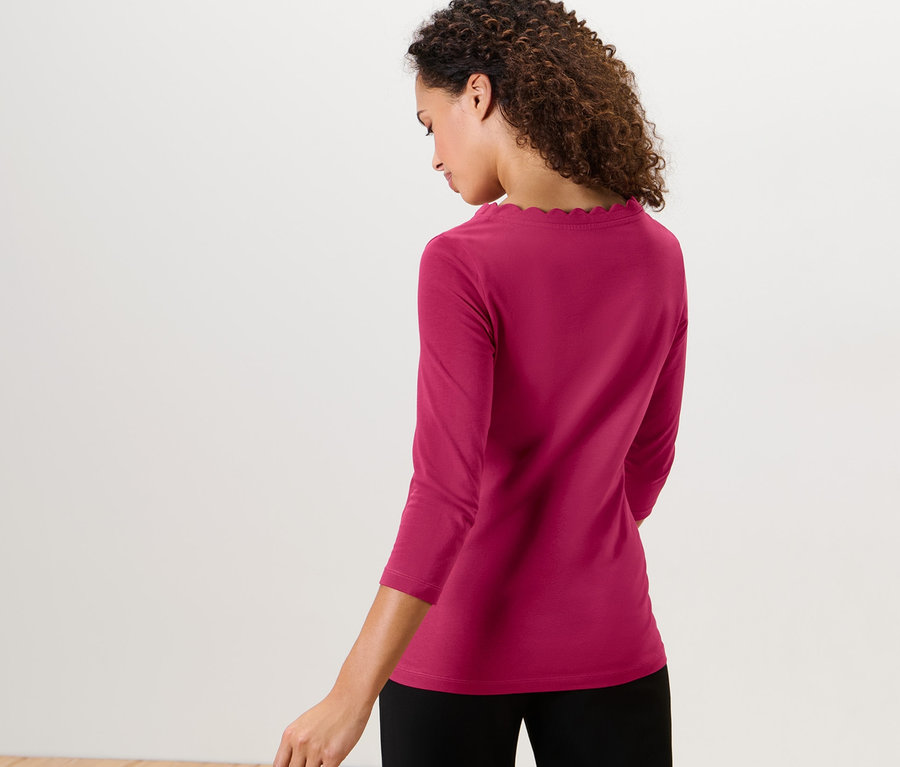 Femme portant un t-shirt manches 3/4 rouge framboise.