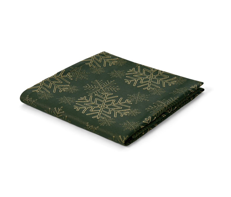 Une nappe en jacquard verte avec des flocons de neige dorés.