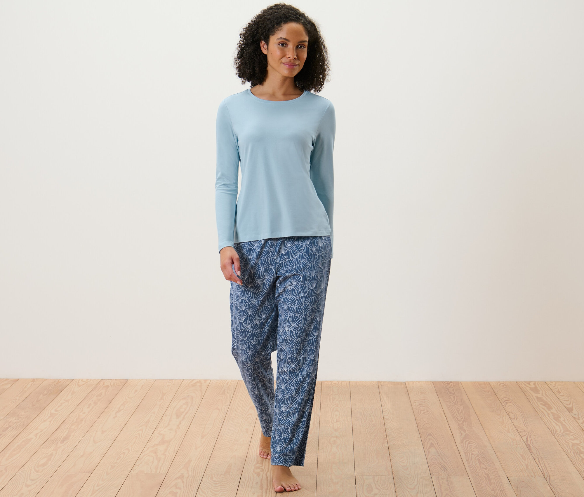Femme portant un pyjama à manches longues et un pantalon à motifs.