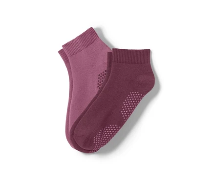 Deux paires de chaussettes de yoga. Une paire est mauve et l'autre violette.