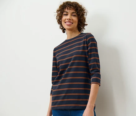 Femme portant un t-shirt manches 3/4 à rayures et un jean.