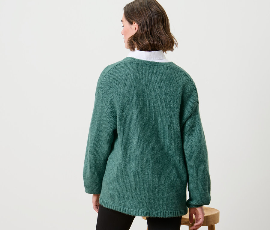 Femme portant un cardigan ouvert en grosse maille.