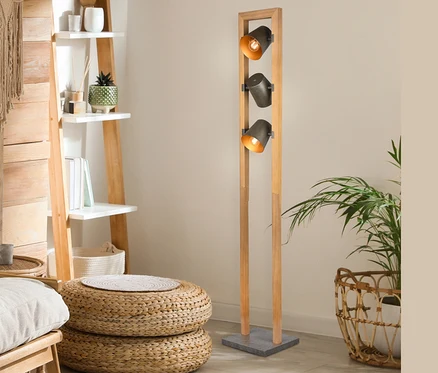 Intérieur avec étagère échelle en bois, poufs en osier et lampadaire Trio Bell à trois lumières.