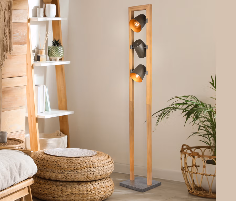 Intérieur avec étagère échelle en bois, poufs en osier et lampadaire Trio Bell à trois lumières.