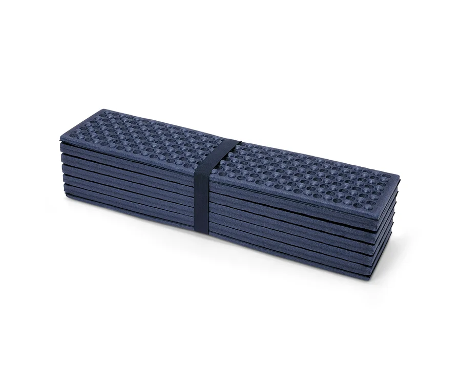 Un tapis isolant pliable maintenu par une sangle bleu foncé sur fond blanc.