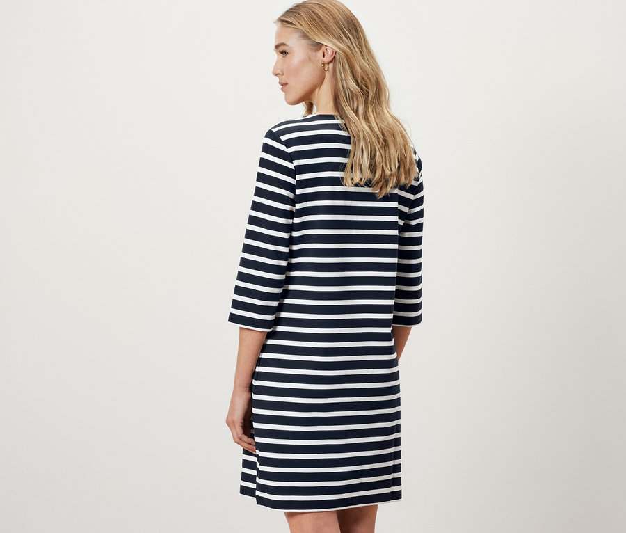 Femme vue de dos portant une robe molletonnée à rayures.