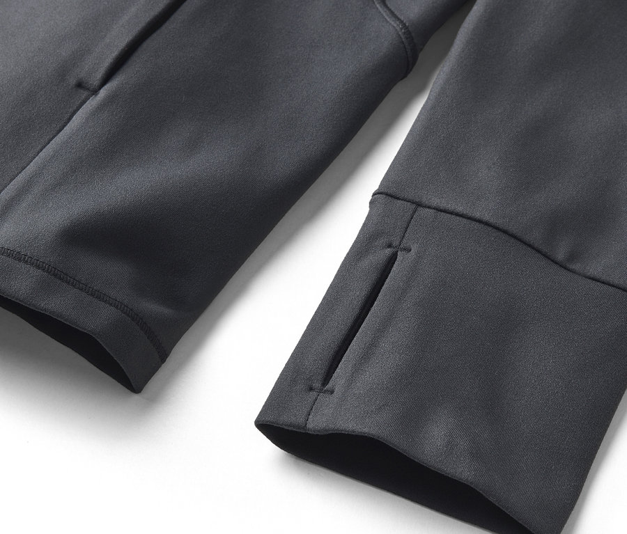 Gros plan sur un sweat-shirt gris avec des trous pour les pouces aux poignets et une poche latérale.
