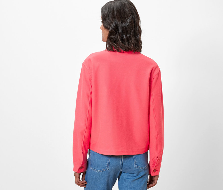 Vue arrière d'une femme portant une veste en jersey et un jean.