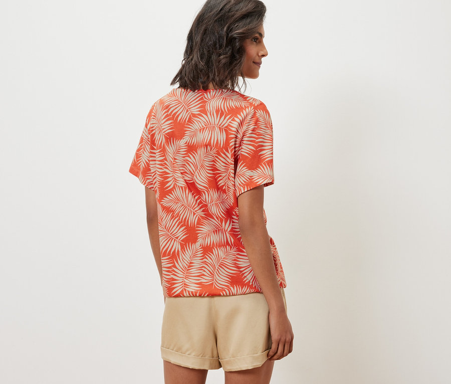 Femme portant une blouse imprimée et un short.