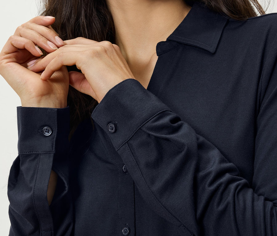 Femme posant les mains sur une chemise bleu marine.