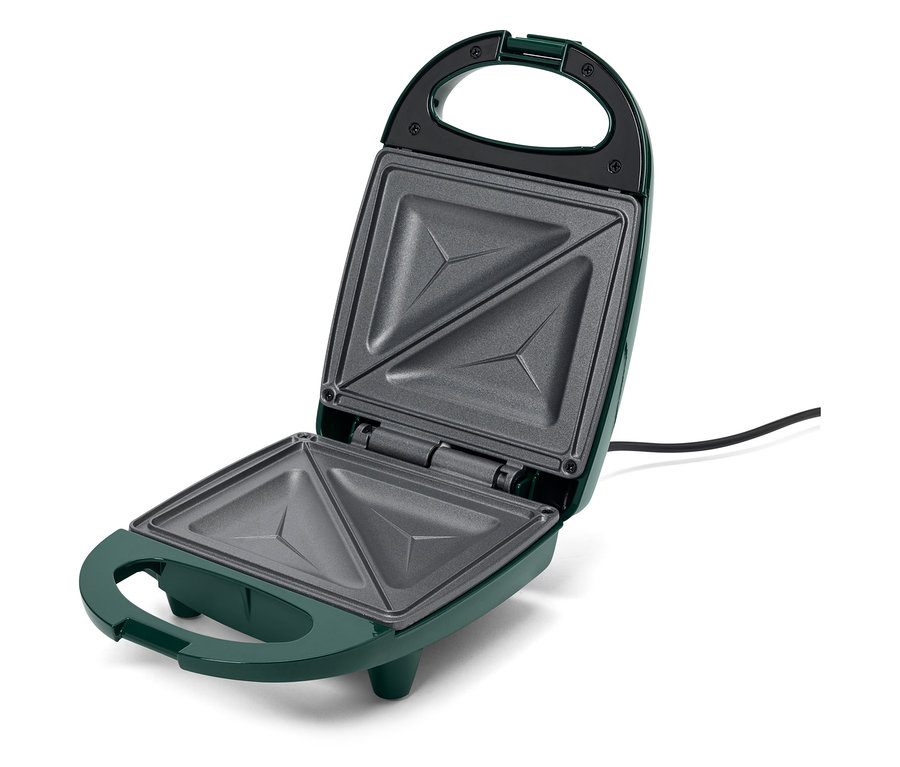 Un appareil à sandwich vert ouvert avec des cavités triangulaires.