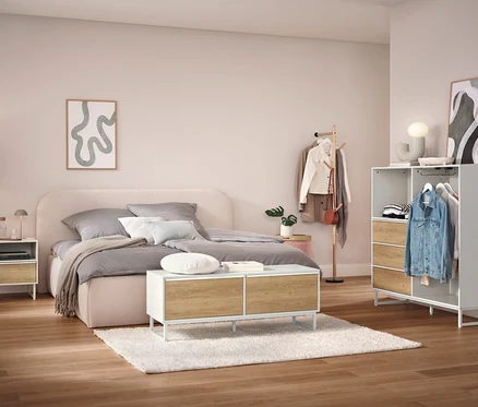 Chambre avec lit, table de chevet, armoire et portant à vêtements.