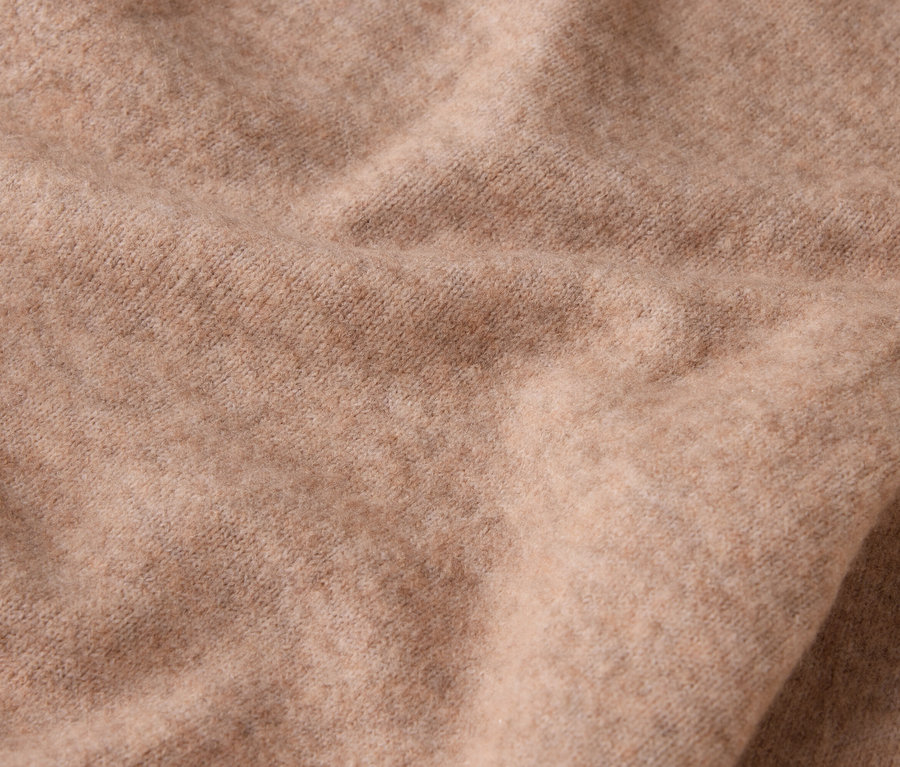Gros plan d'un tissu de laine beige avec des plis.