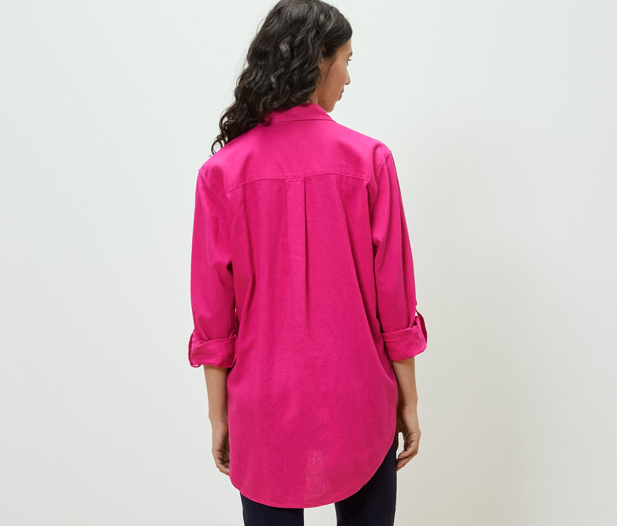 Femme portant une blouse longue en lin rose.