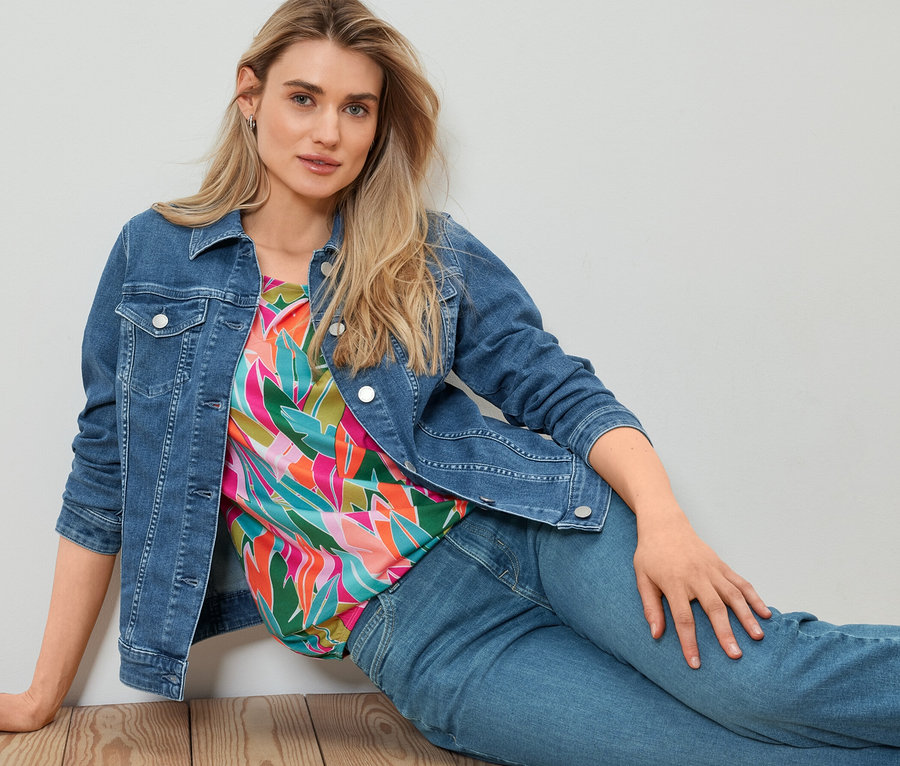 Femme assise par terre portant une veste en jean.