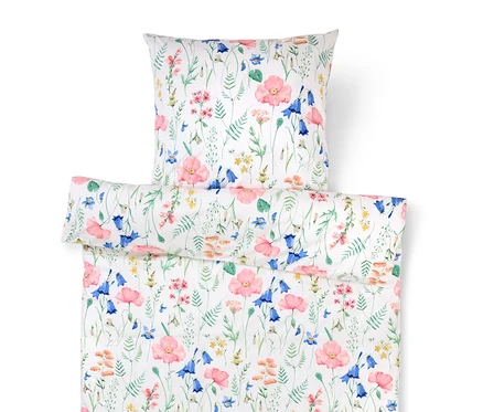 La literie blanche à motif floral présente des coquelicots roses et des campanules bleues.