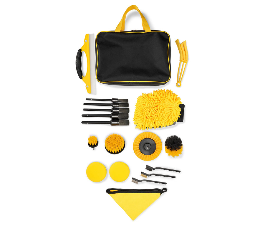 Kit de nettoyage de voiture avec un sac noir à poignées jaunes, un gant de toilette jaune et diverses brosses.
