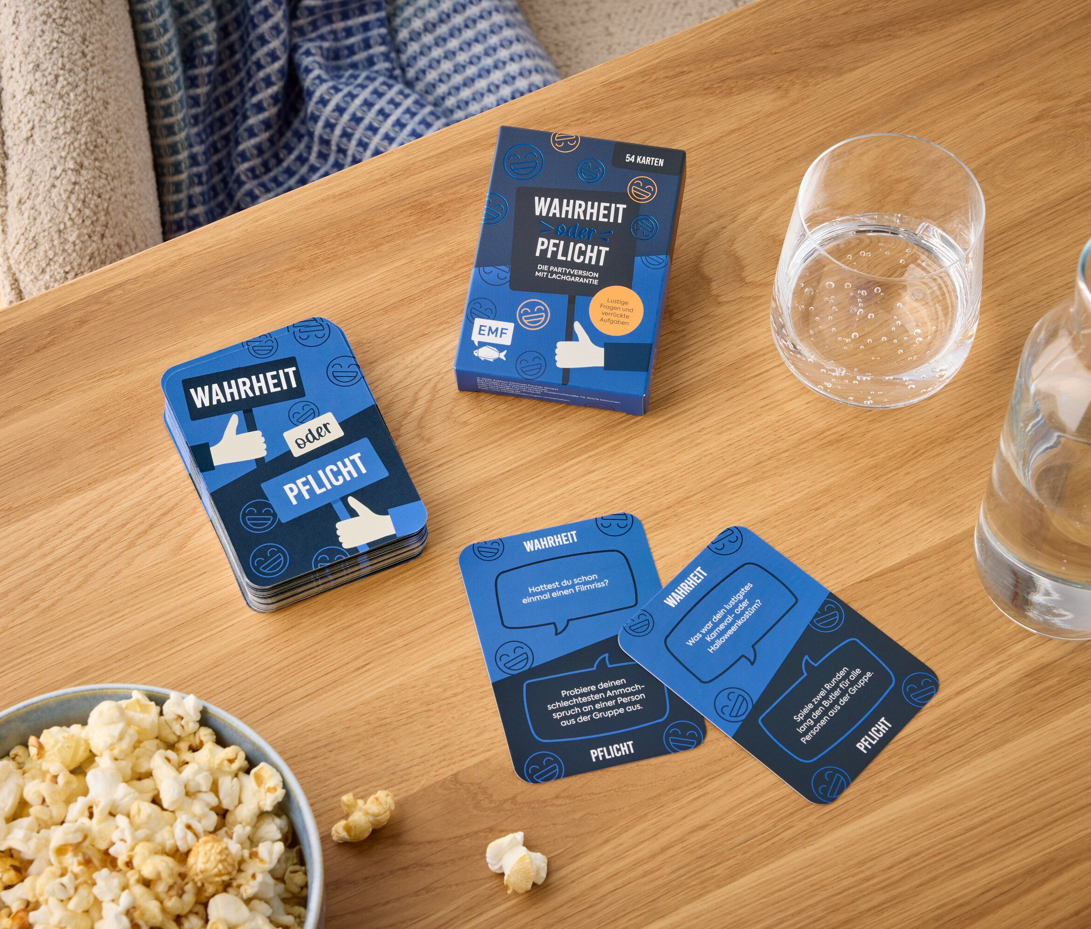 Sur une table en bois se trouvent un bol de pop-corn, un verre d'eau et un paquet de cartes intitulé « Vérité ou Conséquence ».