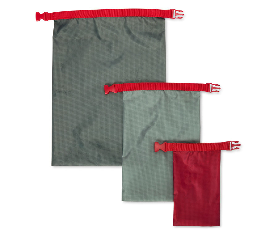 Trois sacs d'emballage dans des tons de gris et de rouge sont placés côte à côte.