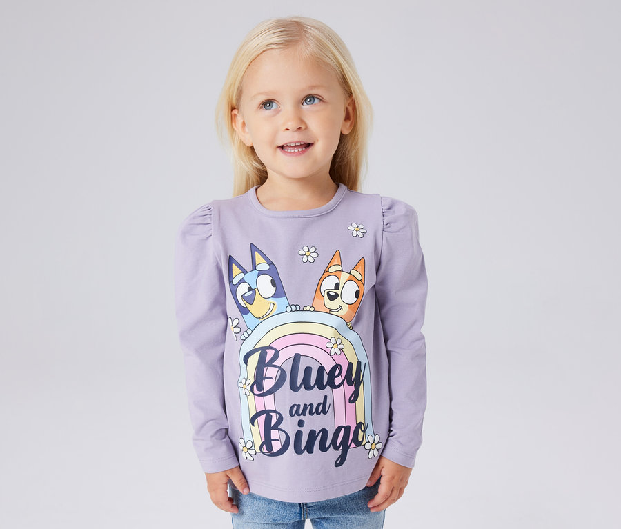 Une fille porte un t-shirt à manches longues NAME IT « BLUEY » violet avec un imprimé Bluey et Bingo.