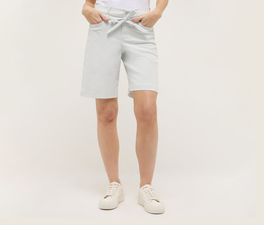 Femme portant un short Angels Denim «
Lia City
», rayures et des chaussures blanches. Ses mains sont dans ses poches.