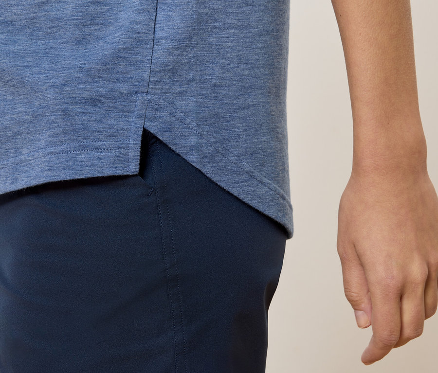 Gros plan d'une personne portant un t-shirt bleu et un pantalon bleu marine.