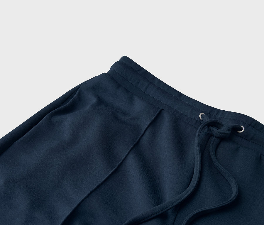 Gros plan d'un pantalon de jogging bleu marine avec cordon de serrage.