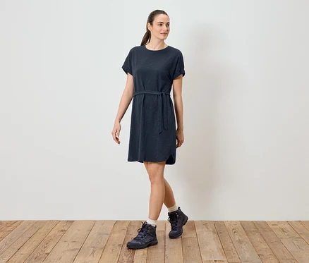 Femme portant une robe t-shirt bleue avec une ceinture et des chaussures de randonnée.