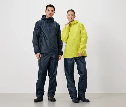 Un homme en veste et pantalon de pluie bleu marine se tient à côté d'une femme en veste de pluie jaune et pantalon de pluie bleu marine.