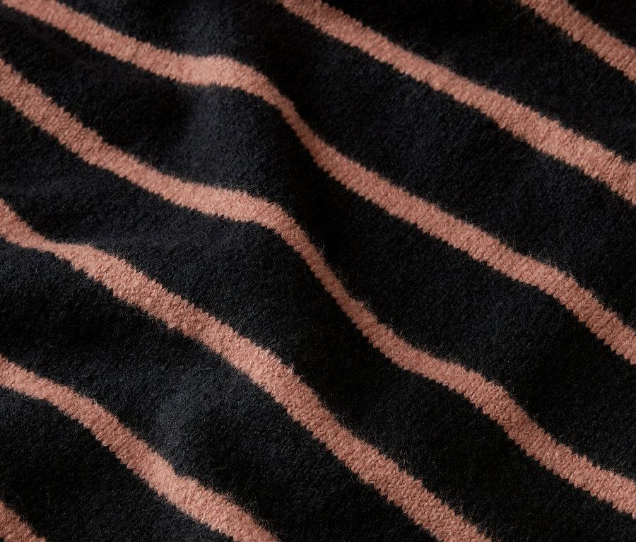 Gros plan d'un tissu foncé avec des rayures obliques marron clair.