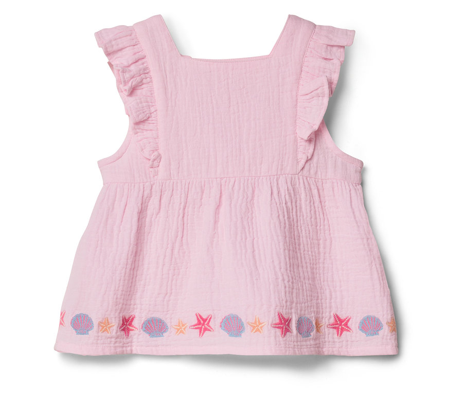 Robe rose sans manches à volants et broderies d'étoiles de mer et de coquillages sur l'ourlet.