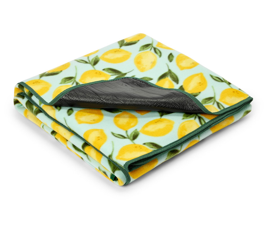 Couverture pliée à motif de citron avec bordure verte.