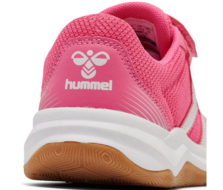 Gros plan de l'arrière d'une chaussure Hummel rose, avec une tige en maille rose, un panneau de talon rose uni avec un logo Hummel blanc, une semelle intermédiaire blanche et une semelle en gomme marron à motif hexagonal.