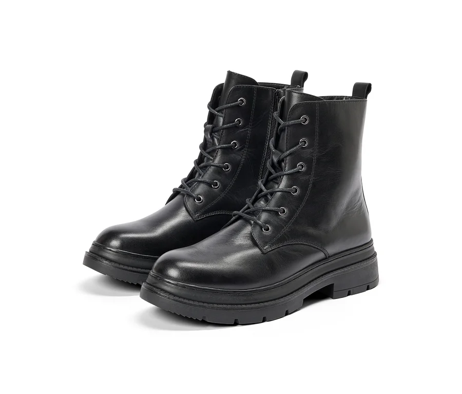 Deux bottes de combat noires avec lacets et fermetures éclair latérales, dotées de semelles épaisses et crantées, sur fond blanc.