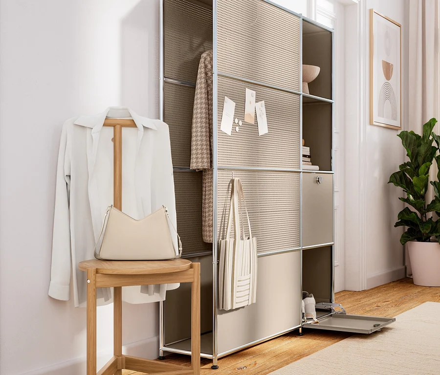 Chemise blanche sur valet de chambre en bois avec tabouret, portant un sac à main clair. À côté, étagère modulaire beige avec veste et sac cabas.
